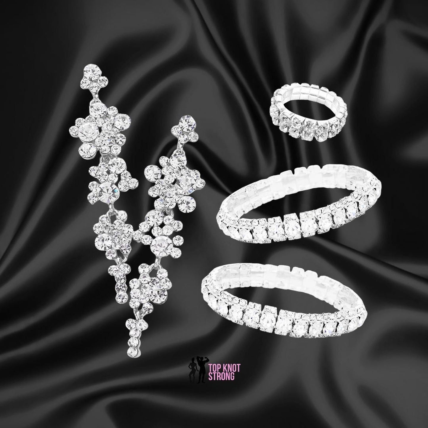 a collection of elegant jewelry pieces, including a pair of dangling earrings, a ring, and a bracelet, all adorned with sparkling diamonds.