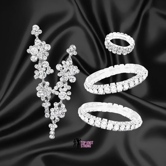 a collection of elegant jewelry pieces, including a pair of dangling earrings, a ring, and a bracelet, all adorned with sparkling diamonds.