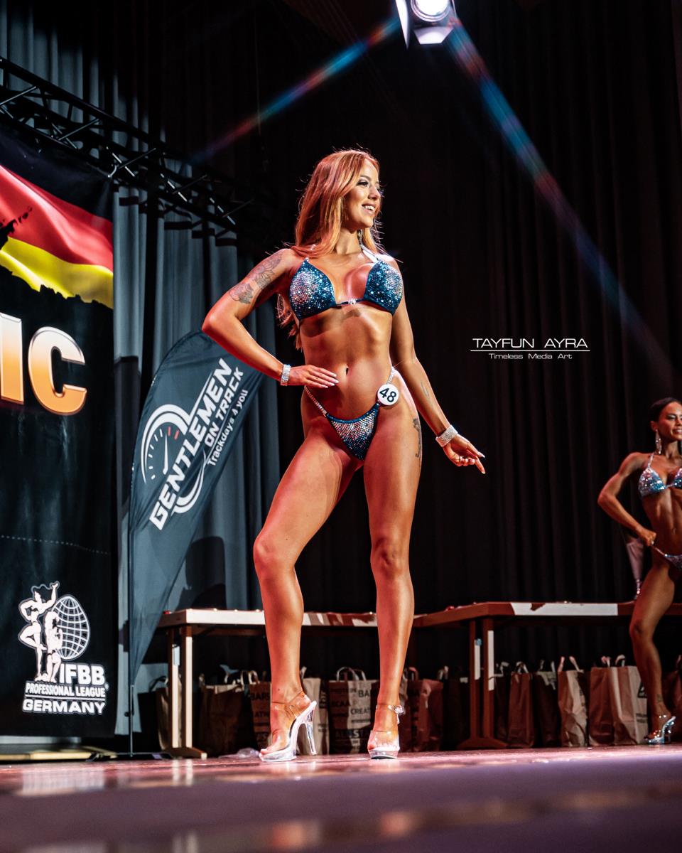 Navy blue bikini competition suit on stage